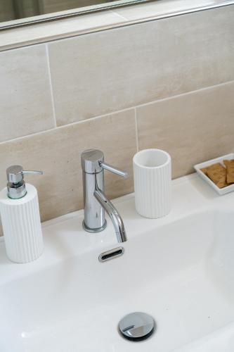 a bathroom sink with two cups and a faucet at Private Jacuzzi - Villa Bellosguardo in Florence Historic Center in Florence