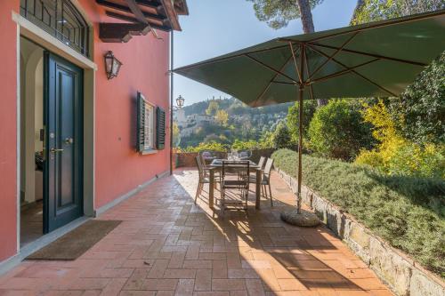 a patio with a table and an umbrella at Private Jacuzzi - Villa Bellosguardo in Florence Historic Center in Florence