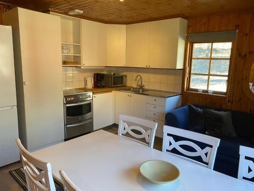 a kitchen with a table and a couch in a room at Kyrkekvarn Stugby in Sandhem