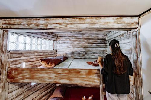 a woman standing in front of a bunk bed at The Onion Collective in Ubud