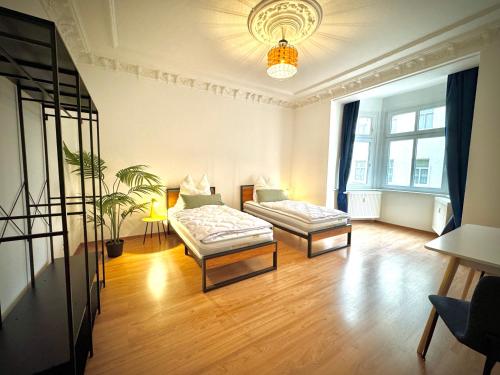 a living room with two beds and a chandelier at #2 RebelRents - 4P - Apartment Smart-TV - WLAN - voll ausgestattete Küche in Zeitz