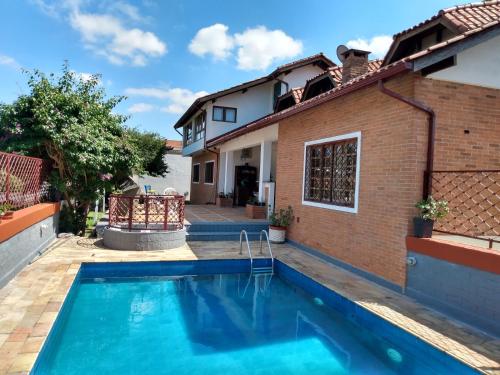 a swimming pool in front of a house at Suítes encantadoras in Sao Paulo
