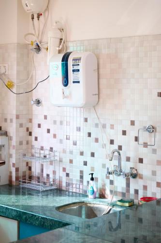 a bathroom with a sink and a machine on the wall at TicAna Apartments with all amenities lake view & terrace garden Ac Kitchen wifi in Udaipur