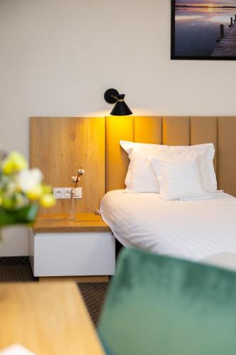a hotel room with a bed and a nightstand with a bed sidx sidx sidx at Hotel ARDEN in Środa Śląska