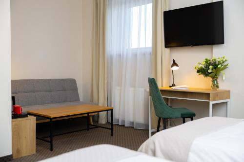 a hotel room with a desk and a chair at Hotel ARDEN in Środa Śląska