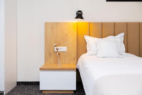 a hotel room with a bed with a white pillow at Hotel ARDEN in Środa Śląska