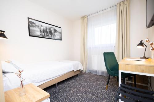 a hotel room with a bed and a desk at Hotel ARDEN in Środa Śląska