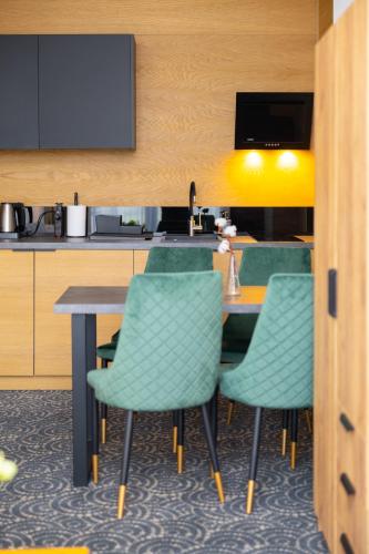 a dining room with a table and green chairs at Hotel ARDEN in Środa Śląska