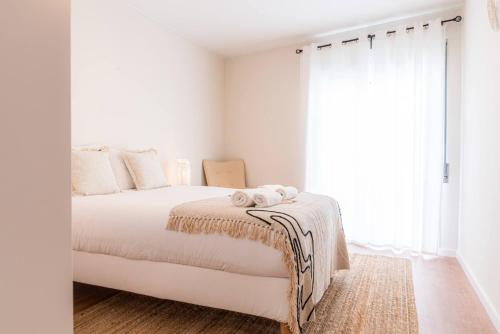 a bedroom with a white bed with a blanket and a window at Morro Garden Apartment by Hosty in Vila Nova de Gaia