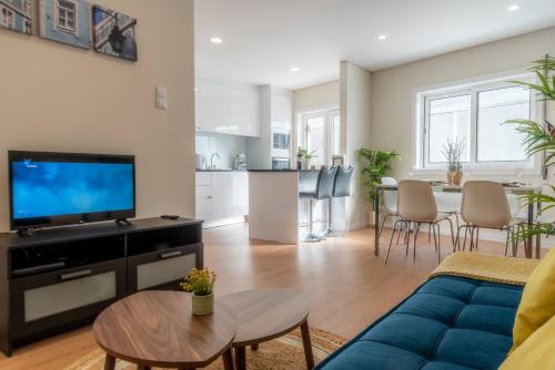 a living room with a blue couch and a kitchen at Morro Garden Apartment by Hosty in Vila Nova de Gaia