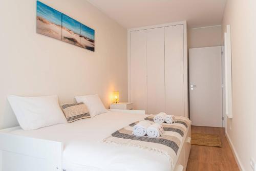 a bedroom with a white bed with towels on it at Morro Garden Apartment by Hosty in Vila Nova de Gaia