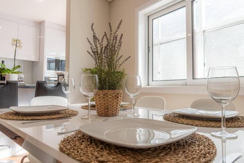 a dining room table with glasses and plates on it at Morro Garden Apartment by Hosty in Vila Nova de Gaia