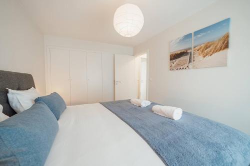 a bedroom with a white bed with a blue blanket at Matosinhos Premium by Hosty in Porto