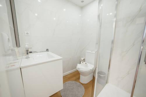a white bathroom with a toilet and a sink at Matosinhos Premium by Hosty in Porto