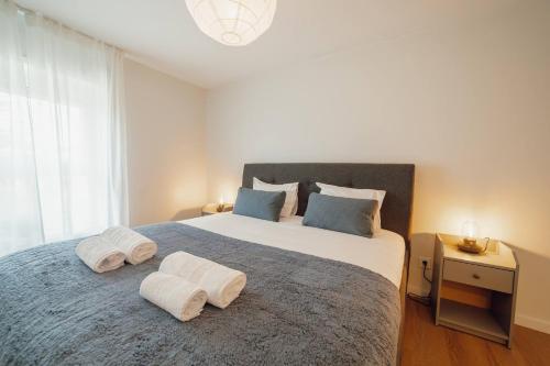 a bedroom with a large bed with towels on it at Matosinhos Premium by Hosty in Porto
