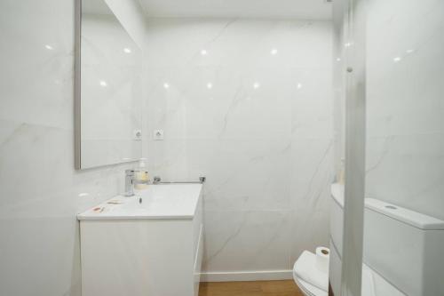 a white bathroom with a sink and a mirror at Matosinhos Premium by Hosty in Porto