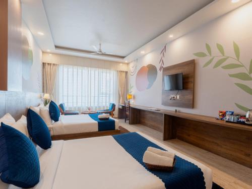 a hotel room with a bed and a tv at Moustache Rishikesh Luxuria in Rishīkesh