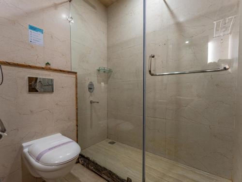 a bathroom with a shower and a toilet at Moustache Rishikesh Luxuria in Rishīkesh