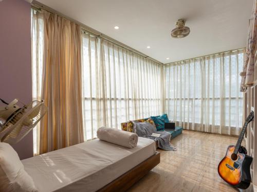 a living room with a bed and a guitar at Moustache Rishikesh Luxuria in Rishīkesh