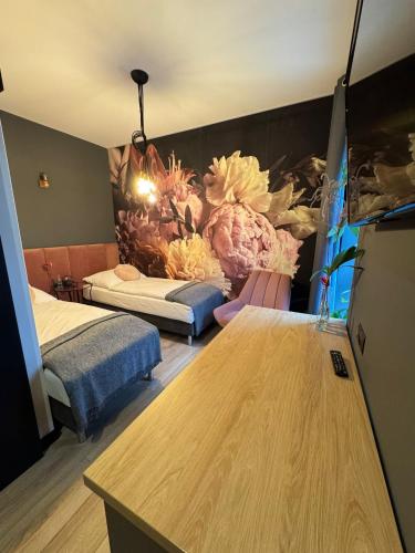 a room with two beds and a table at Klimatyczne pokoje na Ligonia in Turza Śląska