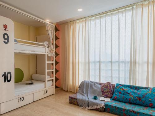 a bedroom with a bunk bed and a couch at Moustache Rishikesh Luxuria in Rishīkesh