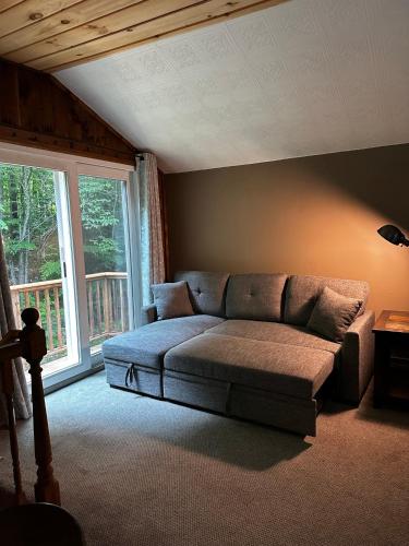 a living room with a couch and a large window at Mandy's Mountain Chalet in Dover