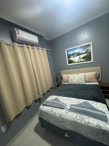 a bedroom with a bed and a air conditioner at Recanto Celestino 3 in São Miguel do Gostoso