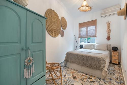 ein Schlafzimmer mit einem Bett und einer blauen Tür in der Unterkunft Casa Gecko in Benalmádena