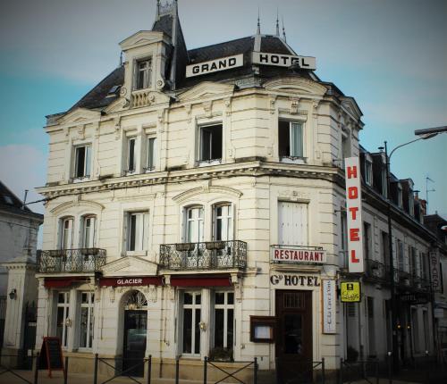 un gran edificio blanco en la esquina de una calle en Logis Le Grand Hotel, en Château-du-Loir