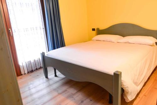 a bed in a room with a large window at Casa Miramonti in Ossana