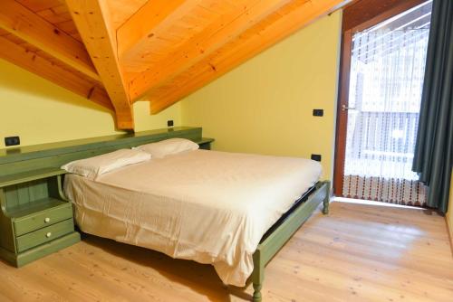 a bedroom with a bed and a large window at Casa Miramonti in Ossana