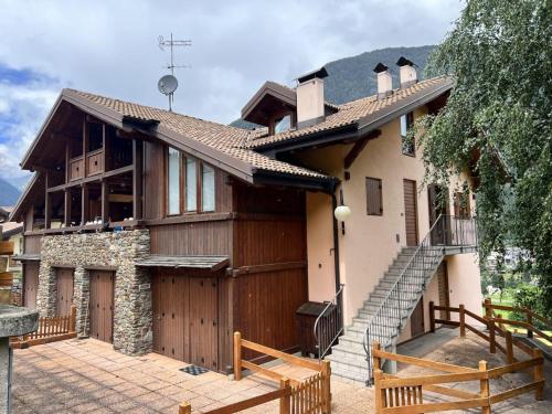 a house with a wooden garage and a staircase at Casa Miramonti in Ossana