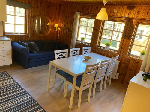 a kitchen and dining room with a table and chairs at Kyrkekvarn Stugby in Sandhem