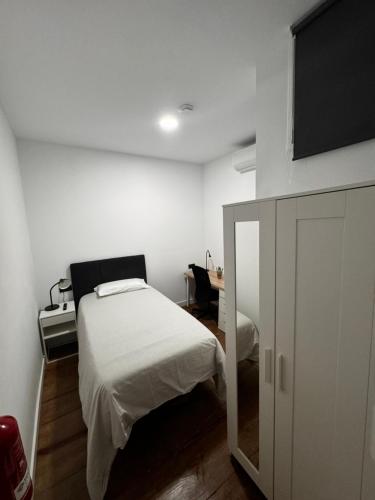 a small bedroom with a bed and a tv at Castillo Emblematic Rooms in Santa Cruz de Tenerife