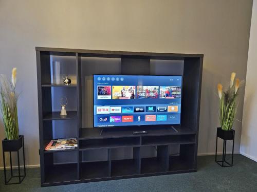 a flat screen tv sitting in a entertainment center at Heart of Old Riga 3 Bedroom Apartment by Dome Square in Rīga