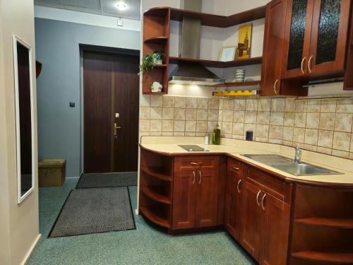 a kitchen with wooden cabinets and a sink at Heart of Old Riga 3 Bedroom Apartment by Dome Square in Rīga