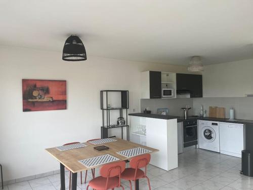 une cuisine avec une table et des chaises dans une pièce dans l'établissement Appartement Le Boïate, à La Teste-de-Buch