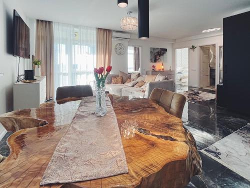 a dining room table with a vase of flowers on it at Violet Superior in Nyíregyháza