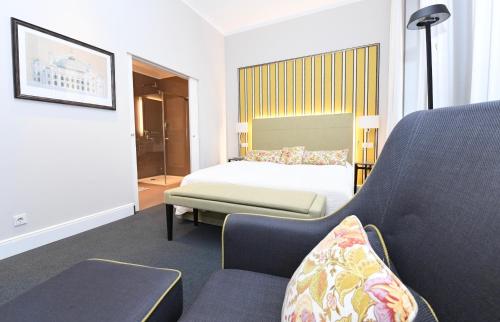 a hotel room with a bed and a chair at Hotel Bischofshof am Dom in Regensburg