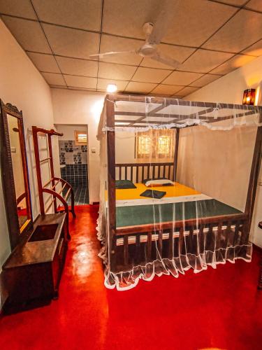 a large bed in a room with a red floor at White House Mirissa in Mirissa