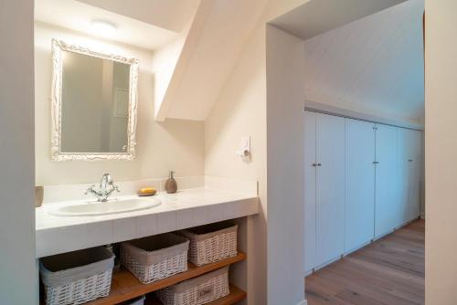 une salle de bain avec un lavabo et un miroir dans l'établissement KER-MYR - Belle Maison de campagne familiale proche sentiers côtiers, à Baden