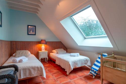 deux lits dans une chambre mansardée avec une lucarne dans l'établissement KER-MYR - Belle Maison de campagne familiale proche sentiers côtiers, à Baden