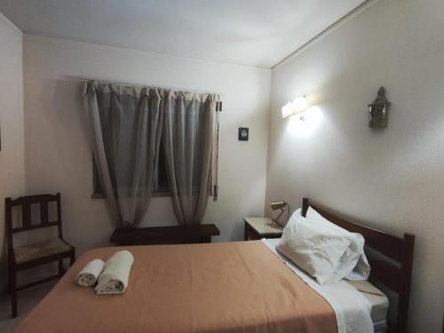 アルマカオ・デ・ペラにあるSea View Apartment in Armação de Pêra, 52 m² + Balconyのベッドと椅子と窓のある寝室