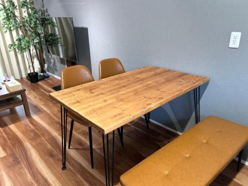 a wooden table and chairs in a room at Hook House Stay Kanazawa in Kanazawa