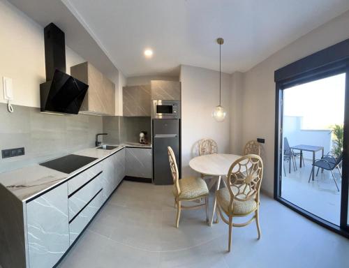 a kitchen and dining room with a table and chairs at La LIPA SUITES con piscina privada in Almáchar