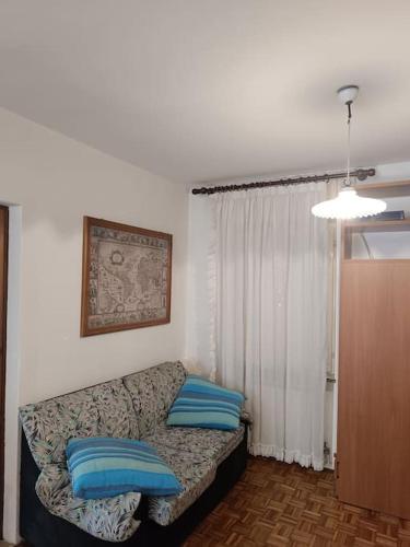 a living room with a couch with blue pillows at La Rotonda in Lastebasse