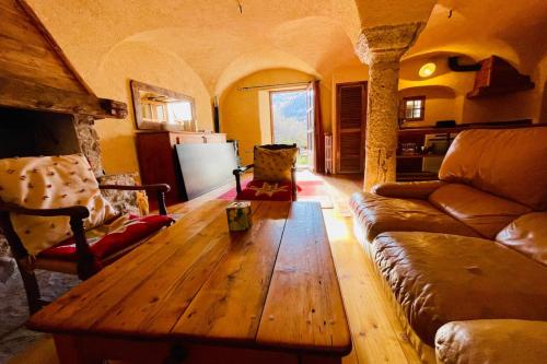 un salon avec un canapé et une table en bois dans l'établissement Spacious apartment in village house, à La Salle Les Alpes