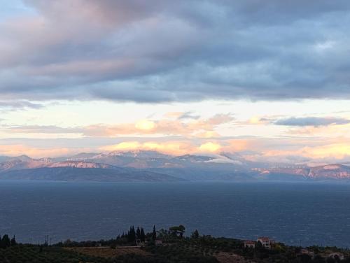 a view of the ocean with mountains in the distance at Altheas Maisonettes in Xylokastron