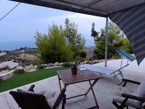 a table and chairs on a patio with a view at Altheas Maisonettes in Xylokastron