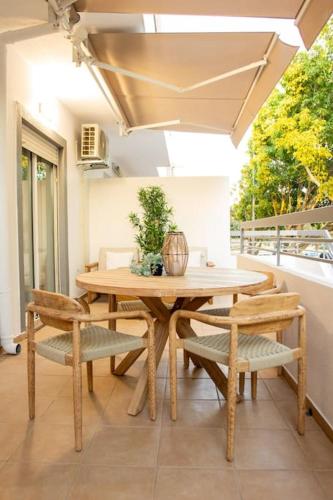 a wooden table and chairs on a patio at RMR Tavira Charm & Comfort in Tavira